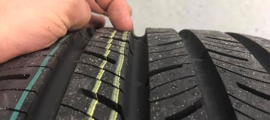 A technician’s hand checking the tire tread. Concept image of “6 Tire Care Tips for National Tire Safety Month” | Griffis Automotive Repair in Orlando, FL.
