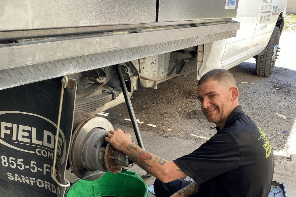 Brake repair services near me in Orlando, FL with Griffis Automotive Repair. Image of mechanic replacing the rear brakes on a Ram 3500