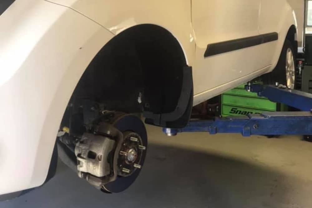 Pre-Holiday Tire and Brake Inspection in Orlando FL At Griffis Automotive Repair. Close-up of car brake and tire lifted in auto repair shop for holiday safety inspection