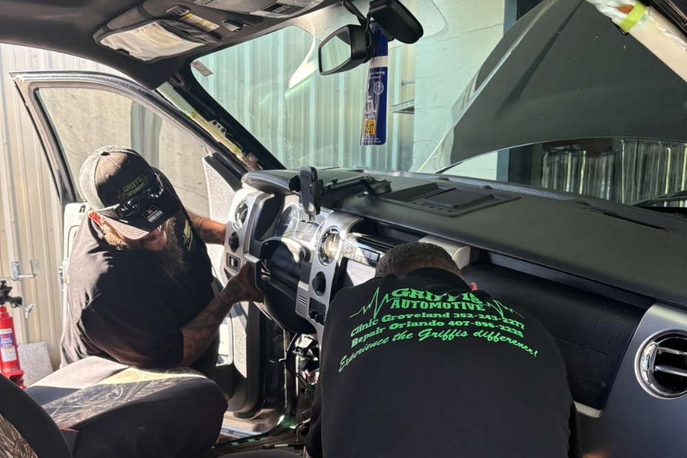 Auto Mechanic Shop in Orlando FL At Griffis Automotive Repair. Two auto mechanics working inside a vehicle near the dashboard in an auto repair shop