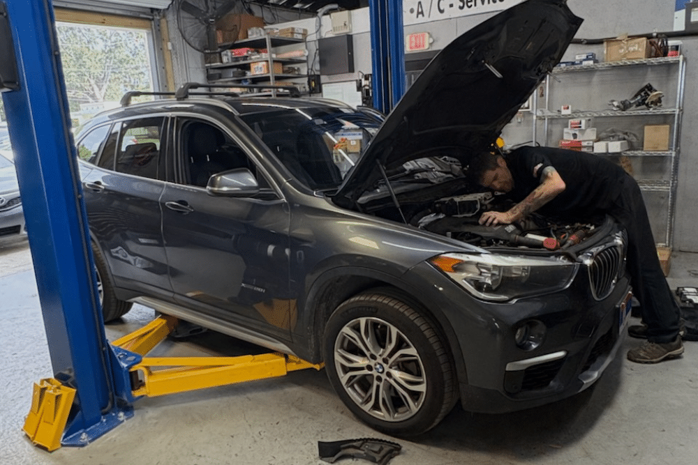 National Car Care Month, Preventative Vehicle Inspection in Orlando FL At Griffis Automotive Repair. Mechanic inspecting a vehicle engine with the hood open during a preventative inspection at an auto repair shop