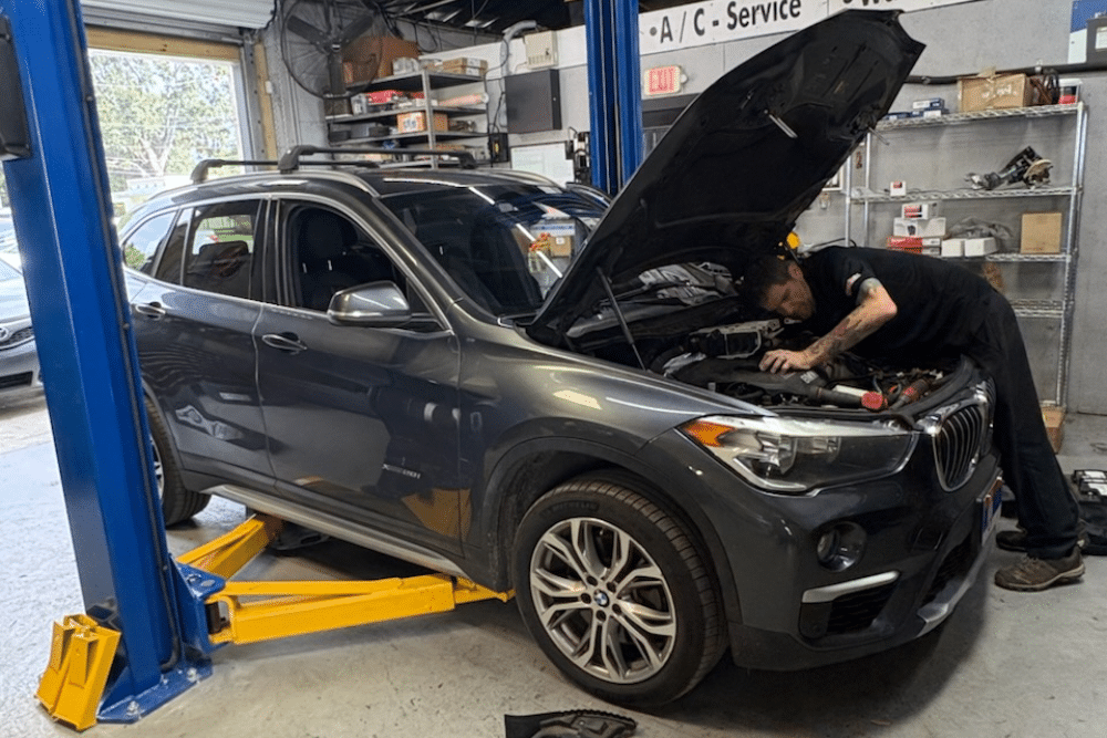 Preventative Maintenance in Orlando FL At Griffis Automotive Repair. Image of Mechanic inspecting a family vehicle engine for routine preventative maintenance